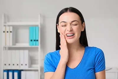 woman experiencing oral pain due to her braces